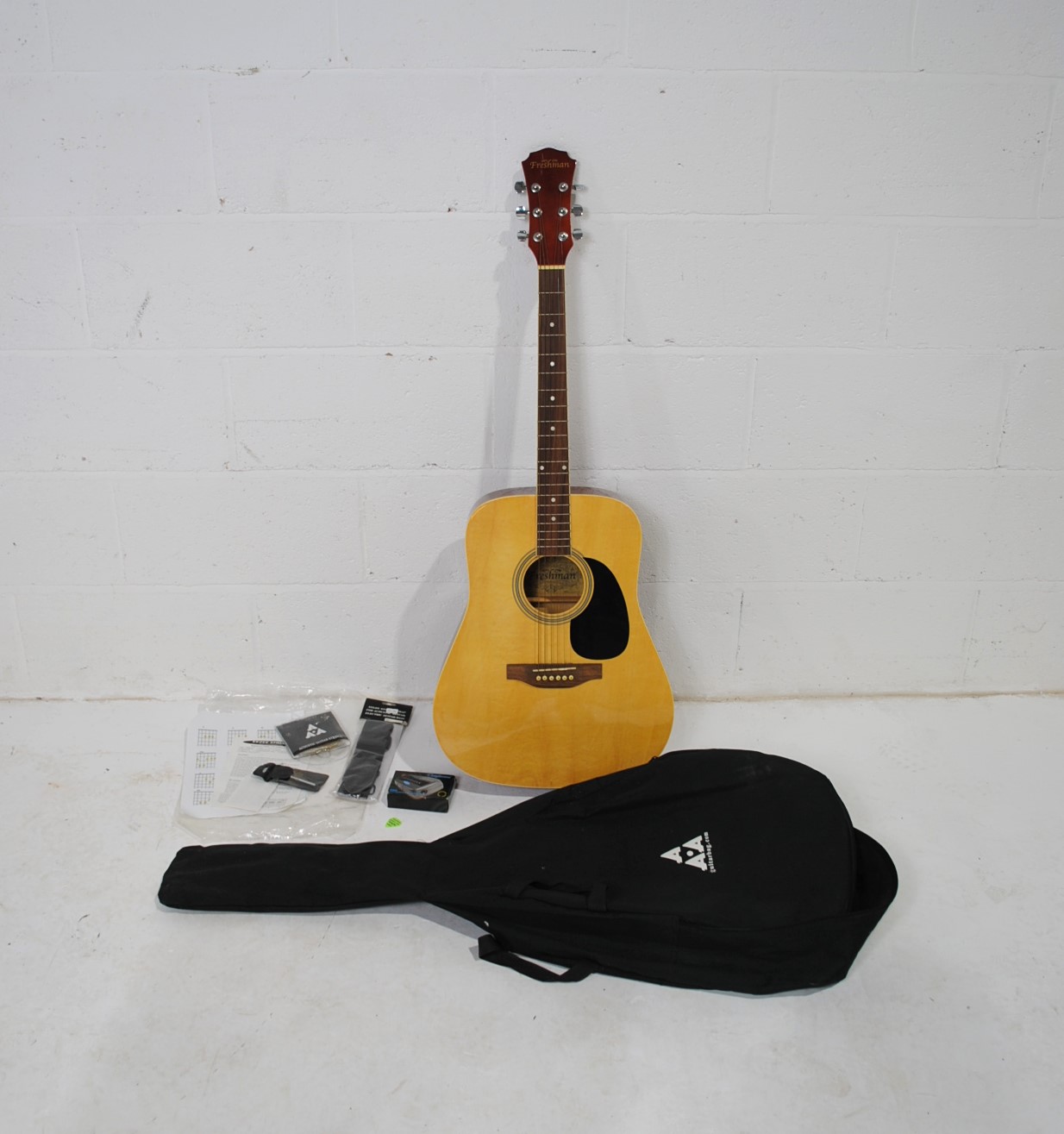 A Freshman six string acoustic guitar, with soft case and accessories