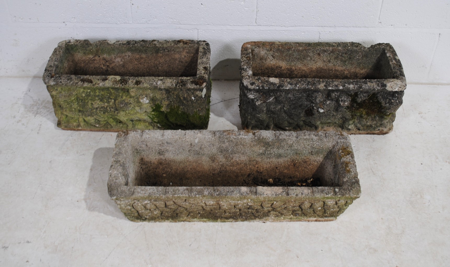 A pair of weathered reconstituted stone garden troughs (length 55cm), along with one other (71cm)