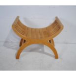 A contemporary wooden X frame stool