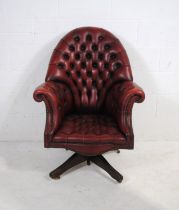 A Chesterfield style red leather swivel chair, with button-back detailing