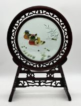 A Chinese hardwood table screen with embroidered panel of ducks on the water on ornately carved