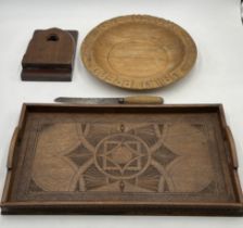 A vintage large wooden bowl with "Give us our Daily Bread" carved around the outside, a carved