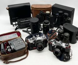 A collection of vintage cameras and binoculars including Praktica, Commodore etc.