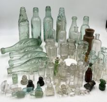 A collection of vintage and antique glass bottles and bottle stoppers