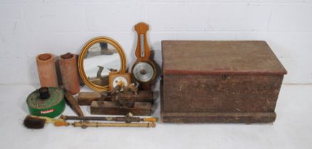 A wooden trunk containing various items, including a wall barometer, gilt framed wall mirror,