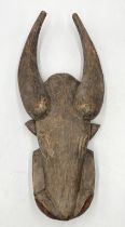 An African carved wooden tribal mask in the form of a buffalo