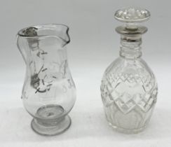 A silver collared glass decanter along with an 18th century glass jug etched with monogram and dated