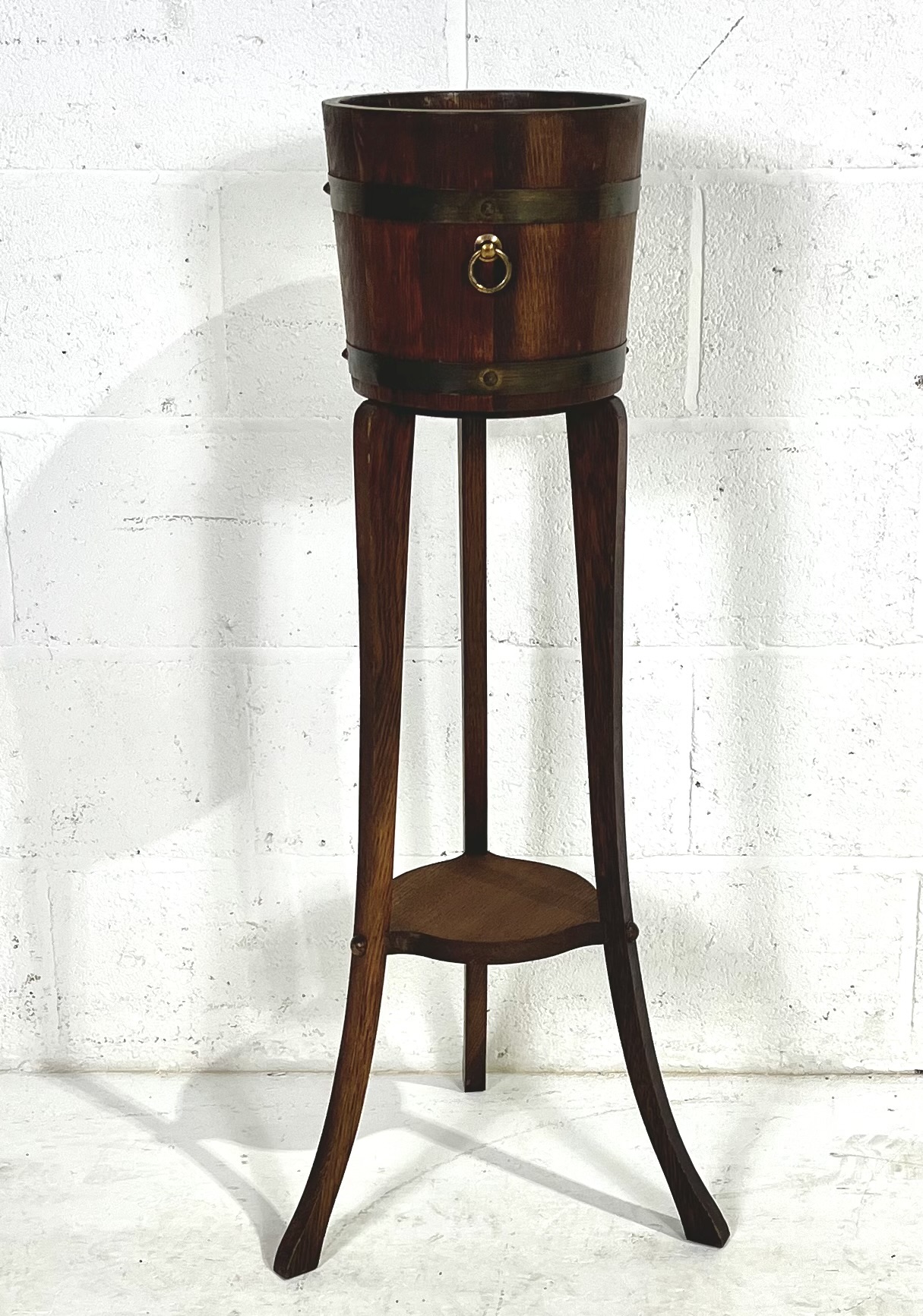 An oak plant stand by R.A. Lister & Co Ltd on tripod legs, height 100cm.