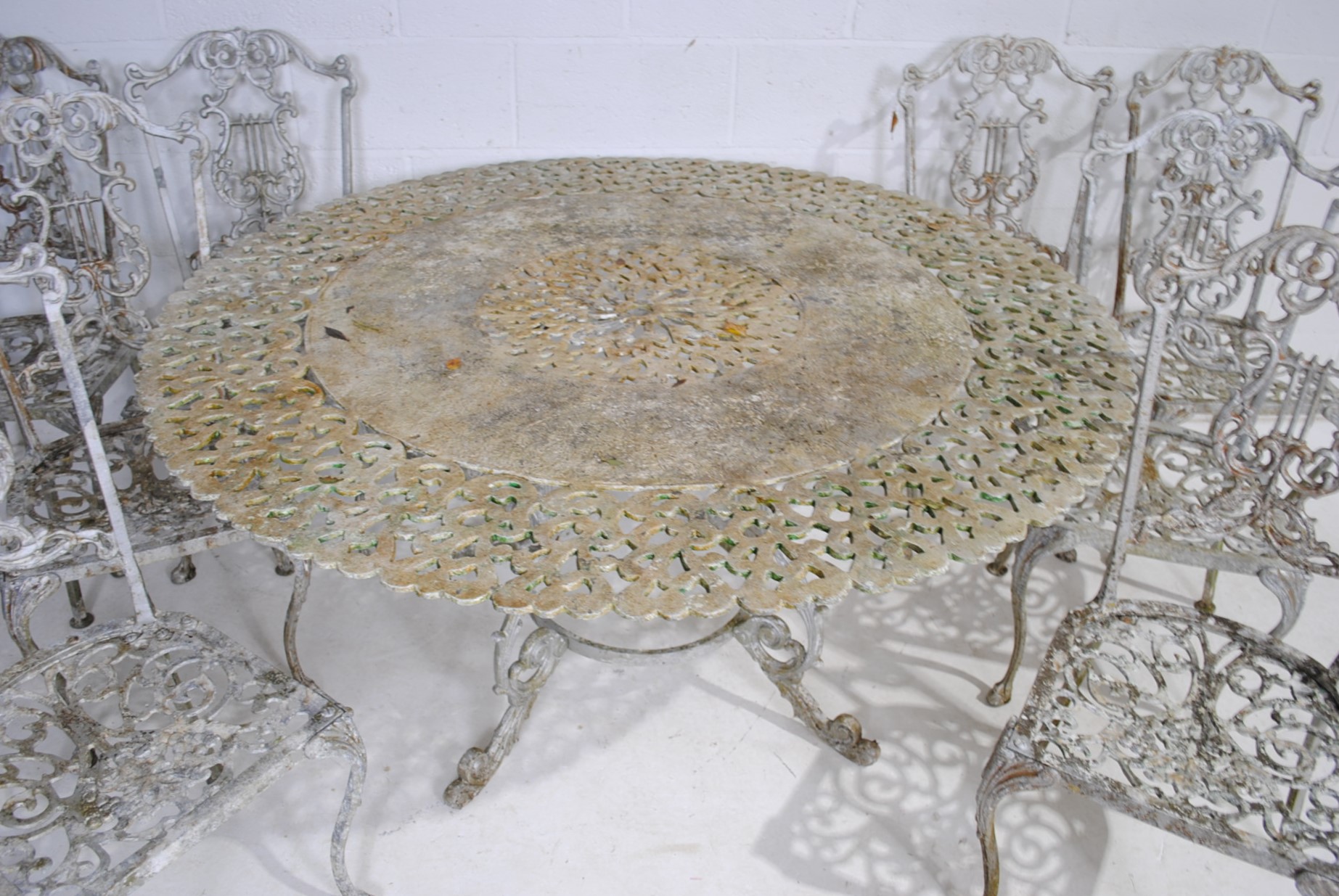 A weathered cast aluminium circular garden table with a set of eight chairs, with lyre backs - one - Image 4 of 12