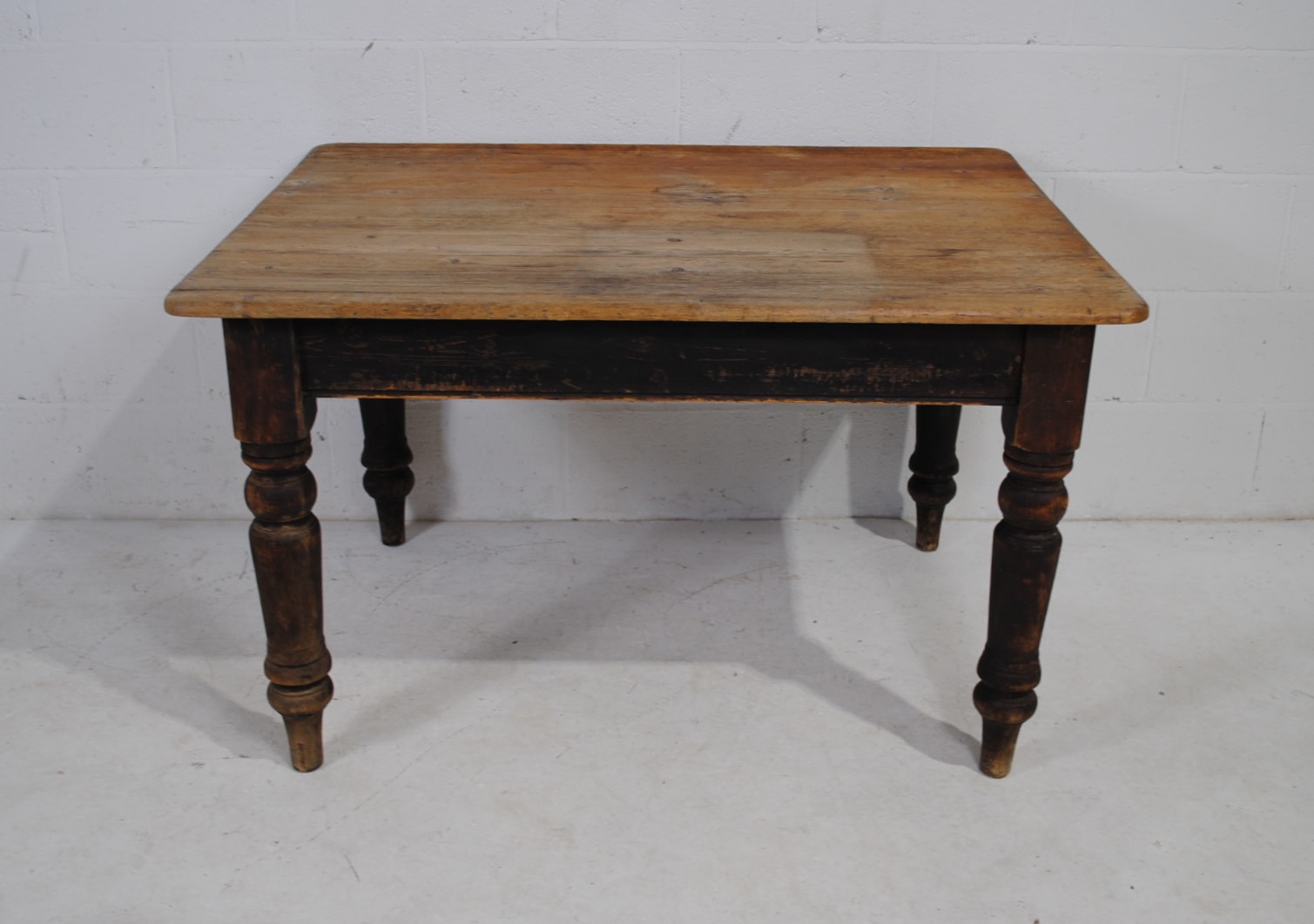 An antique pine farmhouse table, with single drawer, raised on turned legs - length 91cm, depth