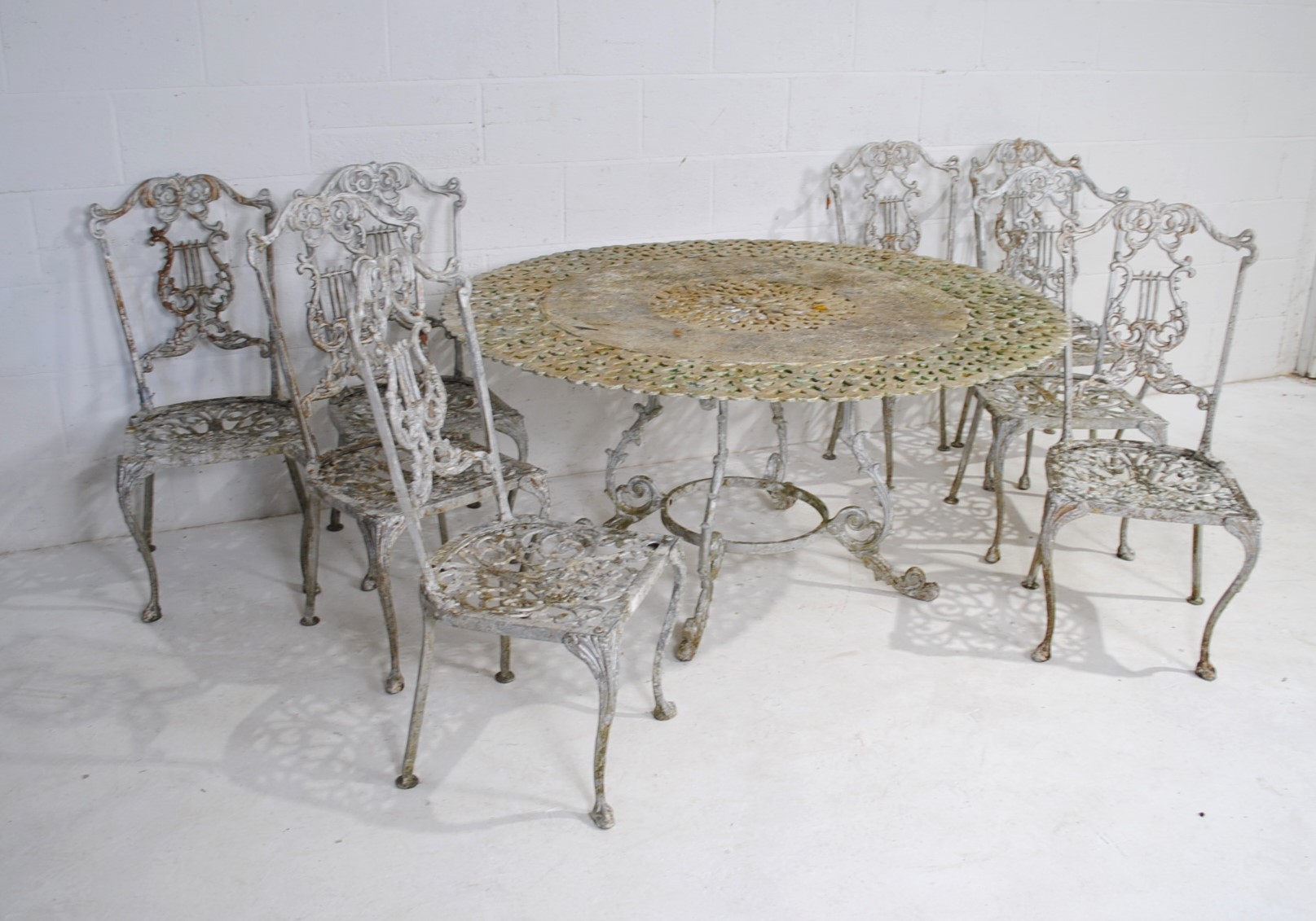 A weathered cast aluminium circular garden table with a set of eight chairs, with lyre backs - one - Image 3 of 12