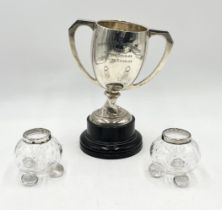 A scrap silver tennis trophy (weight 388.5g) along with a pair of silver rimmed dressing table pots