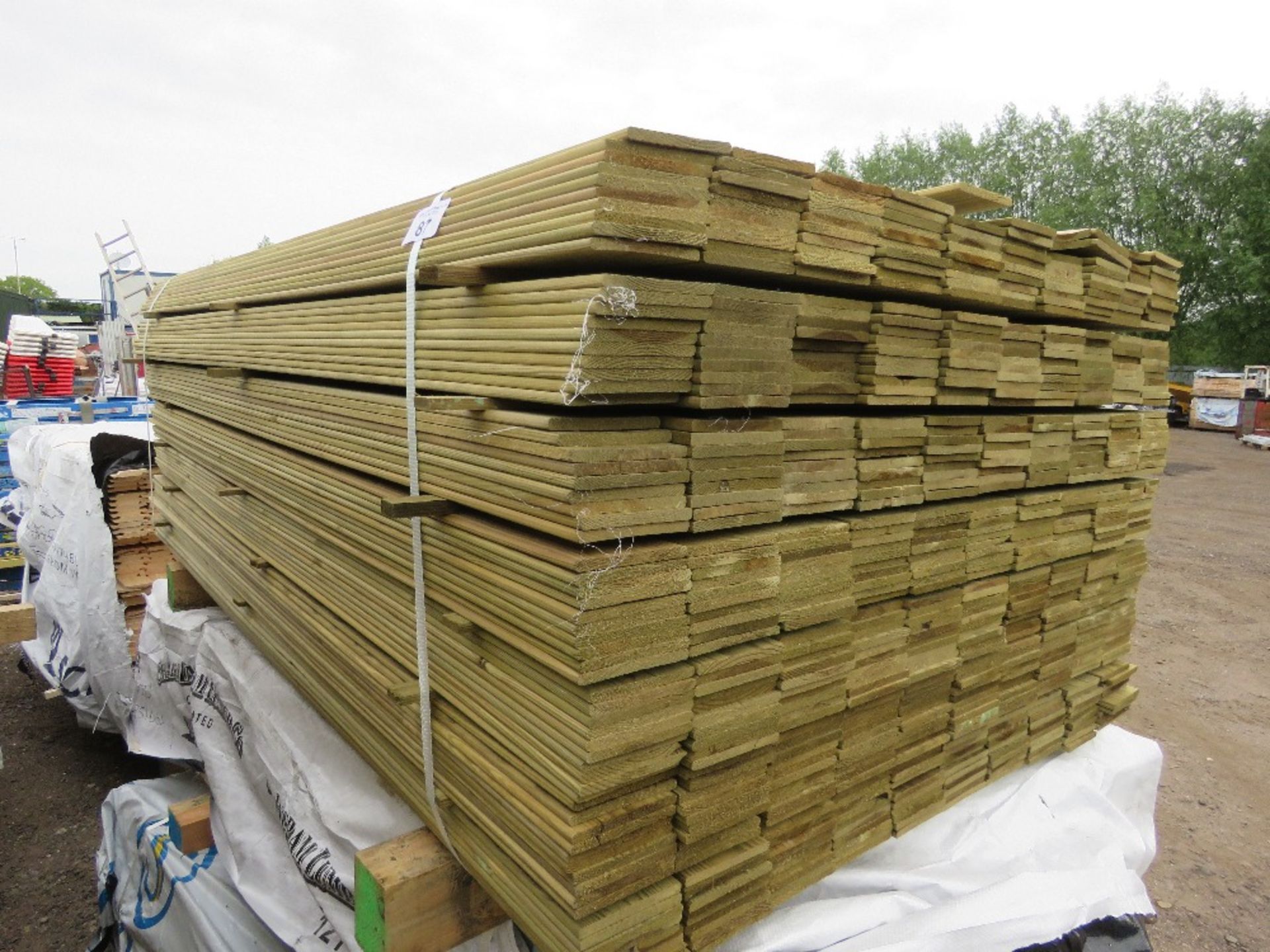 LARGE PACK OF TREATED HIT AND MISS TIMBER CLADDING BOARDS. 1.74M LENGTH X 100MM WIDTH APPROX.