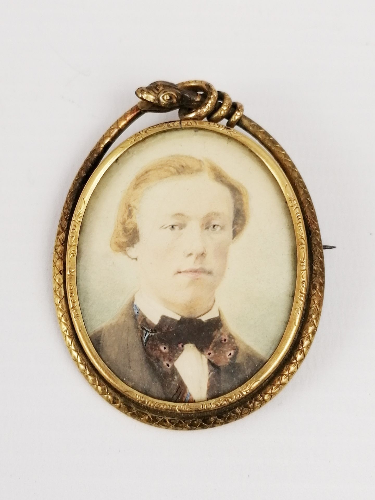 A pearl medallion forming pin, figuring a portrait of aristocrat, the medallion circled with a snake