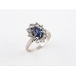 18k gray gold ring (750 thousandths), decorated with a blue faceted stone in a surrounding diamonds