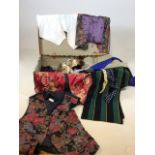A vintage suitcase with mens waistcoats, scarves, ties and other accessories