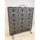 A wrought iron fire guard with scroll detail W:61cm x H:72cm