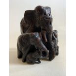 An ornately carved wooden elephant sculpture of seven elephants.