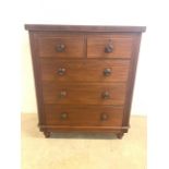 A mahogany veneered chest of drawers with two short over three long drawers with working key and