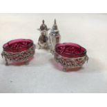 Silver pepperettes, hallmarked, weight 70gm also with 2 white metal salts with cranberry glass