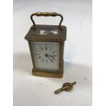 Brass Carriage clock with bevel edge top window, sides and back. Enamel dial with Roman numerals.