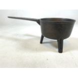 A cast iron early bronze skillet. W:18cm x D:42cm x H:15cm