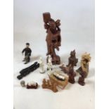 An carved wooden Chinese figure of a man also with carved dragons, an ox. Monkeys, resin figures and