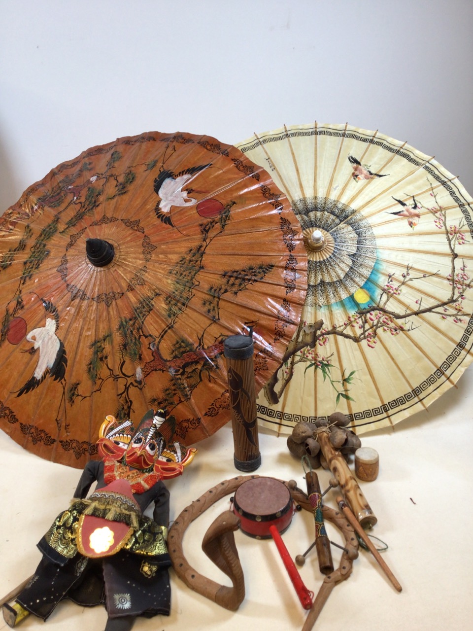 Two hand painted paper parasols, a puppet, reticulated wooden python and other it ed