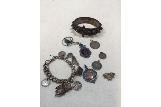 A silver charm bracelet, a silver sweetheart brooch, St Christophers and two presentation sporting - Image 1 of 6