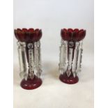 A pair of cranberry glass lustres. Some wear to gilding W:13cm x H:31cm