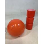 An orange glass retro style Habitat lamp with an orange globe lamp with other items