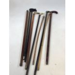 A quantity of walking sticks silver and white metal tops and inlaid decoration, horn handles