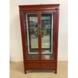 An oriental lacquered mirrored back display cabinet with two glass shelves with light to top. W:93cm