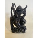 A large oriental carved warrior with riding a dragon dog. With glass eyes. H:34cm