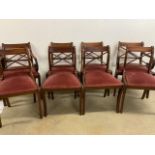 A set of mahogany regency style saber leg drop in seat dining chairs. Two carvers.