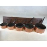 A set of 5 heavy vintage copper pans with wooden board for wooden hanging rack. Largest Diameter