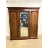 A Victorian mahogany triple wardrobe with large mirrored pin door. Stamped Garnett and sons 2638.