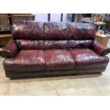 A good quality Oxblood red leather three seater sofa with stud details. W:222cm x D:110cm x H:98cm