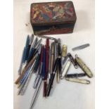 A quantity of pens and pen knives including Parker, Osmiroid in a vintage tea tin