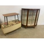 A glazed display cabinet with laundry box and a mid century table.
