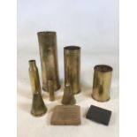 A collection of mainly brass military items including shell cases, a field dressing and other items
