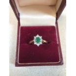 A diamond and emerald cluster ring set in 9 carat gold. Size P/Q. Weight 3 gm. Box not included