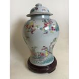 A very large Famille Rose oriental ginger with lid on turned wooden base. H:49cm