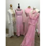 Three vintage very pink lace bridesmaids dresses with one other and a full length lace coat