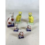 A pair of yellow Staffordshire cats with others H:18cm
