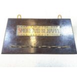 An oak pipe rack with brass plaque - Smoke and be happy. W:29cm x H:14cm