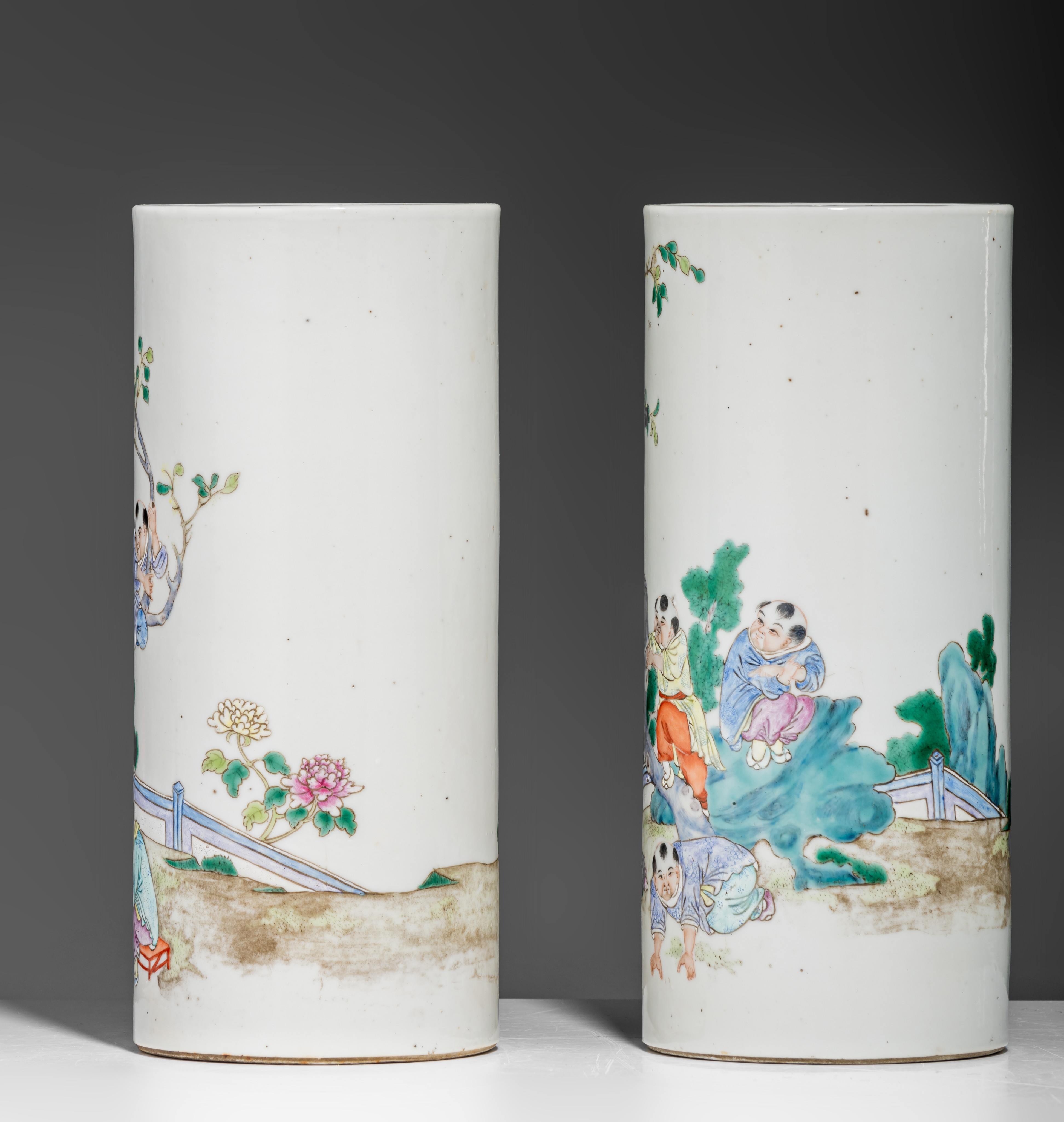 A pair of Chinese famille rose 'Playing boys' cylindrical vases, 19thC/Republic period, H 27,5 cm - Image 3 of 7