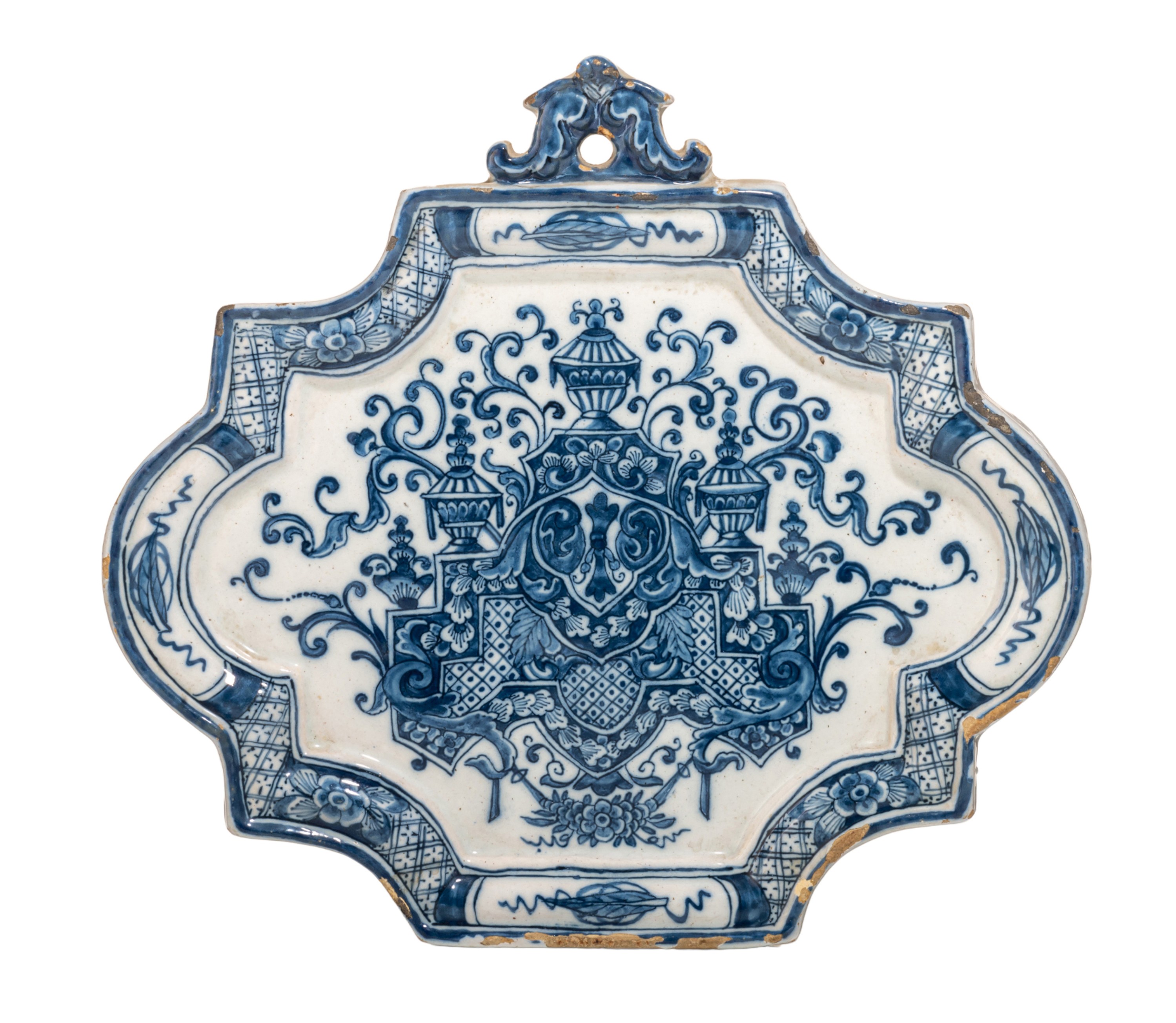 An 18thC Dutch Delft blue and white decorated plaque with a central lambrequin, H 22 cm