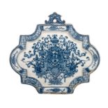 An 18thC Dutch Delft blue and white decorated plaque with a central lambrequin, H 22 cm