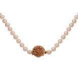 A pearl necklace with a 14ct gold floral-shaped extender, set with a ruby, 71,5 cm - 82,8 g